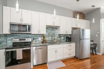 a kitchen with white cabinets and stainless steel appliances at Findlay Market Suite 3 - For 2 in Cincinnati