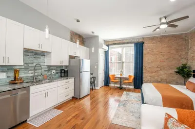 a kitchen and living room with a bed and a refrigerator at Findlay Market Suite 3 - For 2 in Cincinnati
