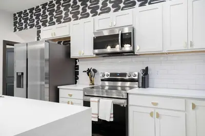 a kitchen with white cabinets and a stainless steel appliance at The Dayton Dream house in Dayton