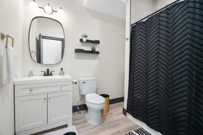 a bathroom with a white toilet and a mirror at The Dayton Dream house in Dayton