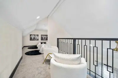 a living room with white chairs and a balcony at The Dayton Dream house in Dayton