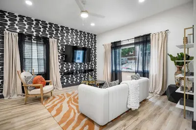 a living room with a white couch and a tv at The Dayton Dream house in Dayton