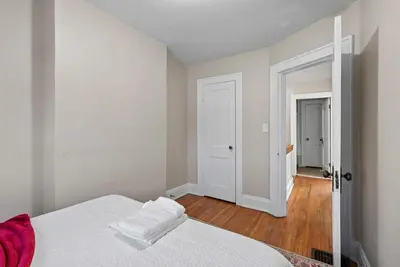 a white bedroom with a bed and a hallway at Tibet Twins 1 Cozy Stay for 6 in Columbus