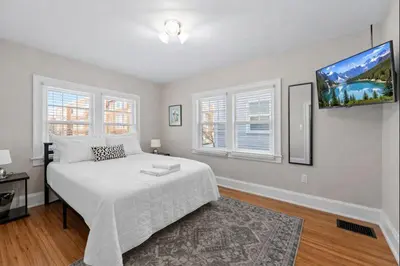 a bedroom with a white bed and a flat screen tv at Tibet Twins 2 Retreat for 6 in Columbus