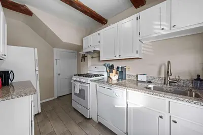 a kitchen with white cabinets and a stove top oven at Tibet Twins Suites For 12 in Columbus