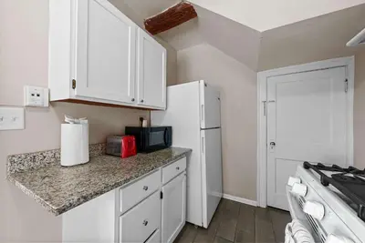 a kitchen with white cabinets and a white refrigerator at Tibet Twins Suites For 12 in Columbus
