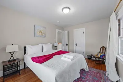 a bedroom with a large white bed with a red blanket at Tibet Twins Suites For 12 in Columbus