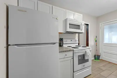 a white kitchen with a refrigerator and a microwave at Tibet Twins Suites For 12 in Columbus