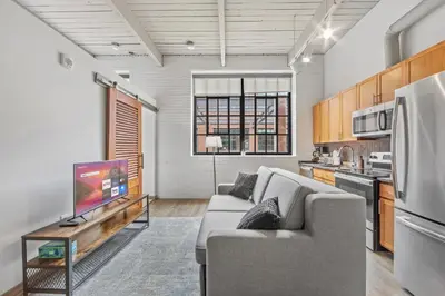 a living room with a couch and a tv at 1 BD Apt l Downtown l Parking l Fast Wi-Fi l Café in Cleveland