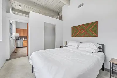 a white bedroom with a large bed and a kitchen at 1 BD Apt l Downtown l Parking l Fast Wi-Fi l Café in Cleveland