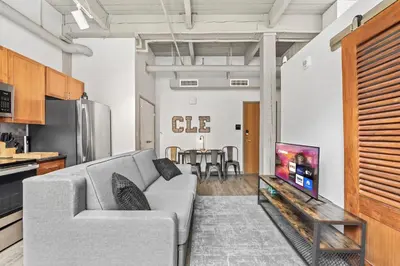a living room with a couch and a tv at 1 BD Apt l Downtown l Parking l Fast Wi-Fi l Café in Cleveland