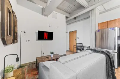 a living room with a couch and a tv on the wall at Downtown Loft l Cleveland l Parking l Cafe in Cleveland