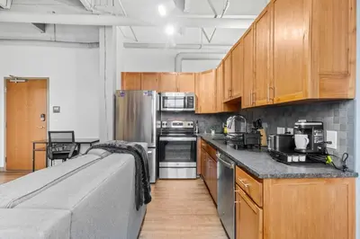 a kitchen with wooden cabinets and stainless steel appliances at Downtown Loft l Cleveland l Parking l Cafe in Cleveland