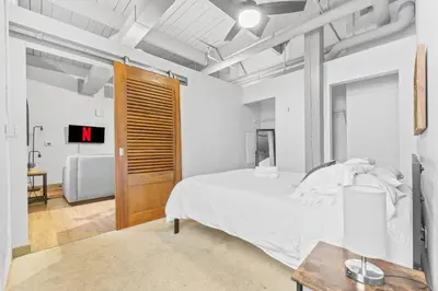 a bedroom with a white bed and a wooden door at Downtown Loft l Cleveland l Parking l Cafe in Cleveland