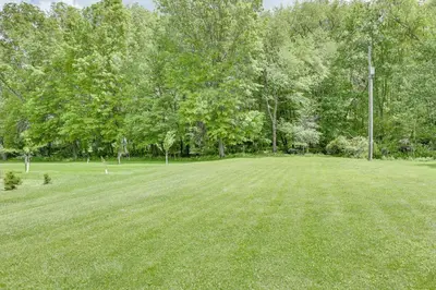 a large grass field with trees in the background at 6 Mi to Main Street Dog-Friendly Home in Dover! in Dover