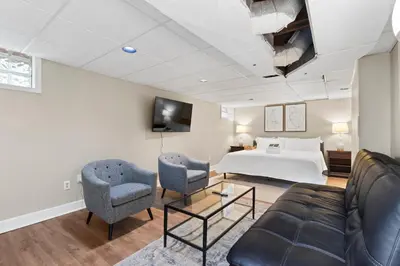 a hotel room with a bed and a couch and chairs at Inviting 4BR2BA in Oakley with 2 Park Spots & Lg Deck in Cincinnati