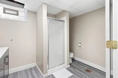 a bathroom with a toilet and a glass door at Inviting 4BR2BA in Oakley with 2 Park Spots & Lg Deck in Cincinnati
