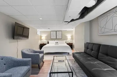 a hotel room with a bed and two chairs and a couch at Inviting 4BR2BA in Oakley with 2 Park Spots & Lg Deck in Cincinnati