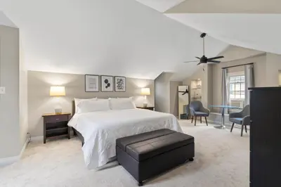 a bedroom with a white bed and a table and chairs at Inviting 4BR2BA in Oakley with 2 Park Spots & Lg Deck in Cincinnati
