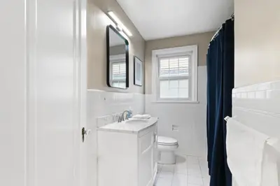 a white bathroom with a sink and a toilet at Inviting 4BR2BA in Oakley with 2 Park Spots & Lg Deck in Cincinnati