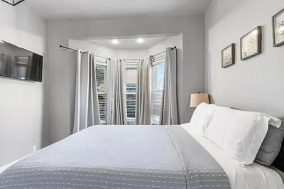 a white bedroom with a bed and a window at HydePark Abode Two 1st flr bedrms in Cincinnati