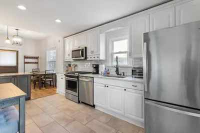 a kitchen with white cabinets and a stainless steel refrigerator at HydePark Abode Two 1st flr bedrms in Cincinnati