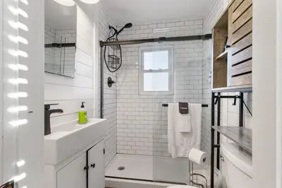 a white bathroom with a shower and a sink at HydePark Abode Two 1st flr bedrms in Cincinnati