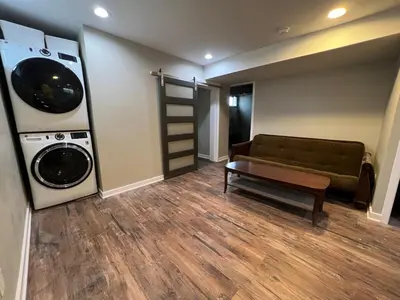 a living room with a couch and a washer and dryer at Newly renovated Spacious & Cozy 3Bd Home in Oakley in Cincinnati