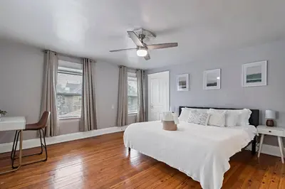 a white bedroom with a bed and a ceiling fan at Walkable and Central with 1st flr bedroom and bathroom in Cincinnati