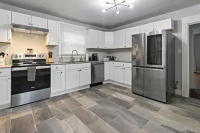 a kitchen with white cabinets and stainless steel appliances at Walkable and Central with 1st flr bedroom and bathroom in Cincinnati