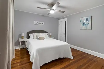 a white bedroom with a bed and a ceiling fan at Walkable and Central with 1st flr bedroom and bathroom in Cincinnati