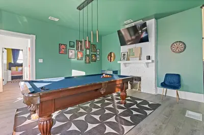 a room with a pool table and a fireplace at WalnutHills Mansion-sleeps14! TVs in every room! in Cincinnati
