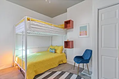 a bedroom with a bunk bed and a blue chair at WalnutHills Mansion-sleeps14! TVs in every room! in Cincinnati