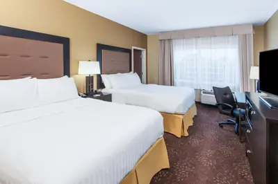 a hotel room with two beds and a desk at Holiday Inn Express & Suites Sandusky by IHG in Sandusky