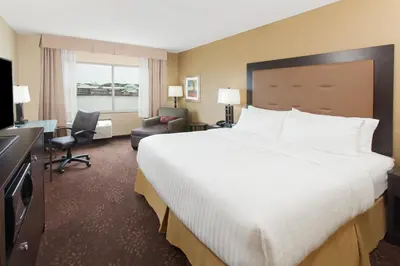 a hotel room with a large bed and a television at Holiday Inn Express & Suites Sandusky by IHG in Sandusky
