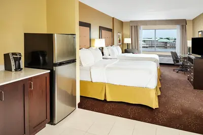 a hotel room with two beds and a kitchen at Holiday Inn Express & Suites Sandusky by IHG in Sandusky