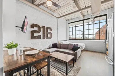 a living room with a couch and a table at Studio Apt In DT l Parking l Fast Wi-fi l Café in Cleveland