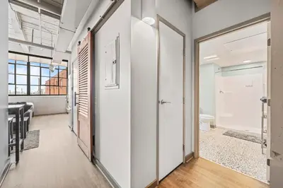 a hallway with white walls and a bathroom with a toilet at Studio Apt In DT l Parking l Fast Wi-fi l Café in Cleveland