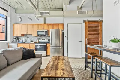 a living room with a couch and a table at Studio Apt In DT l Parking l Fast Wi-fi l Café in Cleveland