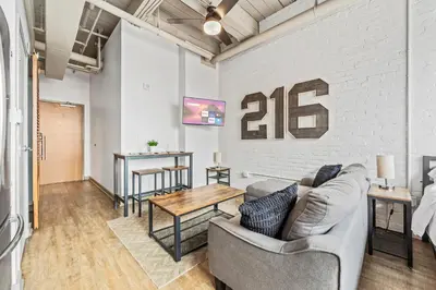 a living room with a couch and a table at Studio Apt In DT l Parking l Fast Wi-fi l Café in Cleveland