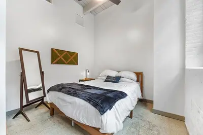 a white bedroom with a bed and a mirror at Brooklyn Style Loft l DT l Parking l Cafe in Cleveland