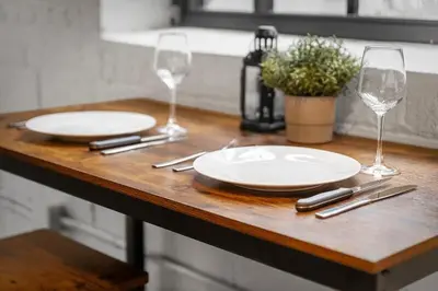 a wooden table with two plates and wine glasses at Brooklyn Style Loft l DT l Parking l Cafe in Cleveland