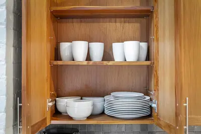 a cabinet filled with white bowls and plates at Brooklyn Style Loft l DT l Parking l Cafe in Cleveland