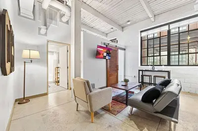 a living room with a couch and a chair at Brooklyn Style Loft l DT l Parking l Cafe in Cleveland