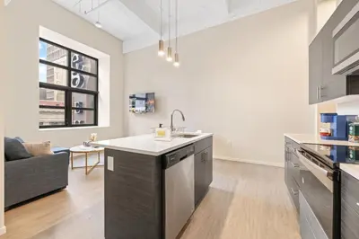 a kitchen with a sink and a living room at Luxury DT Condo l Playhouse Square l Fast W-Fi in Cleveland