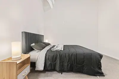 a bedroom with a bed with a black blanket and a nightstand at Luxury DT Condo l Playhouse Square l Fast W-Fi in Cleveland