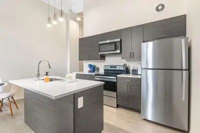 a kitchen with a stainless steel refrigerator and cabinets at Luxury DT Condo l Playhouse Square l Fast W-Fi in Cleveland