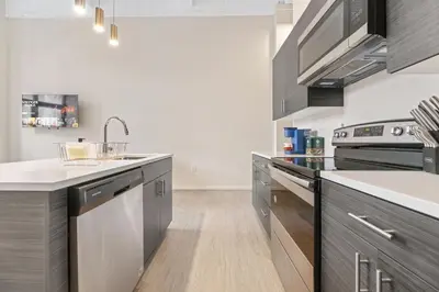 a kitchen with stainless steel appliances and a sink at Luxury DT Condo l Playhouse Square l Fast W-Fi in Cleveland
