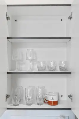 a row of glasses on a shelf in a kitchen at Luxury DT Condo l Playhouse Square l Fast W-Fi in Cleveland