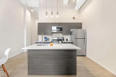 a kitchen with a stainless steel refrigerator and cabinets at Luxury DT Condo l Playhouse Square l Fast W-Fi in Cleveland